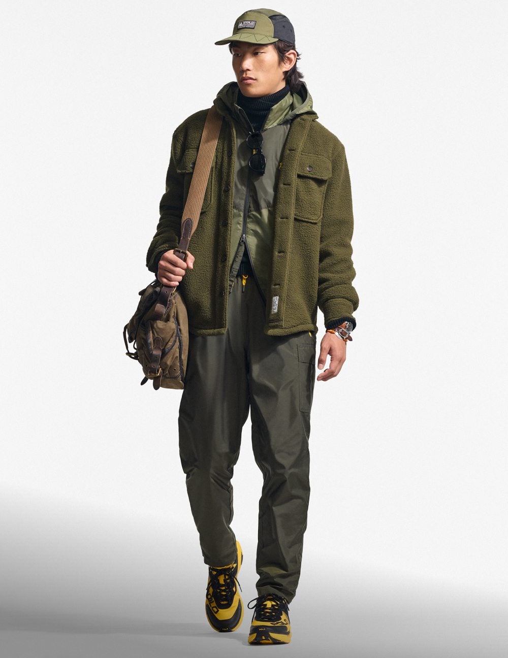 Man wears green fleece jacket over grey outfit.