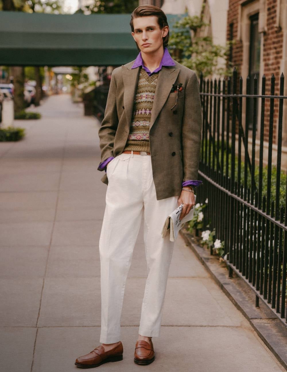 Man wears sport coat over Fair Isle sweater vest and pleated chinos.